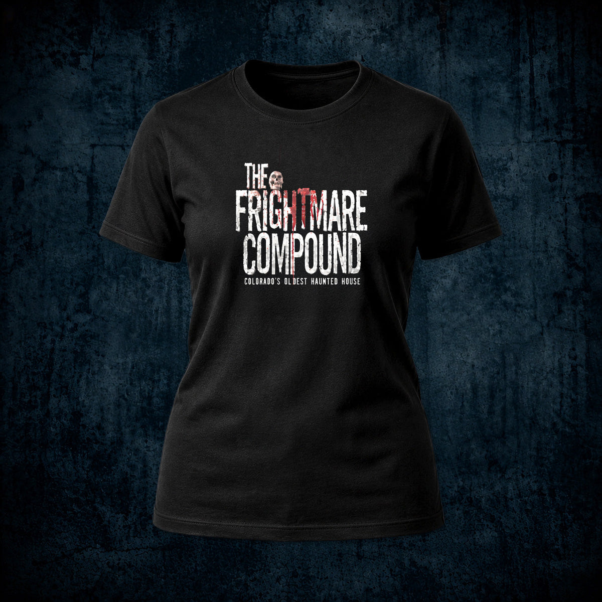 A black short-sleeve crewneck t-shirt featuring a distressed white and red graphic print that reads 'THE FRIGHTMARE COMPOUND' with 'COLORADO'S BEST HAUNTED HOUSE' underneath, displayed against a dark textured blue background.