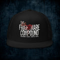 A black trucker hat with a distressed white and red graphic reading 'The Frightmare Compound' and 'Colorado's Oldest Haunted House' on the front panel, shown against a dark textured blue background.