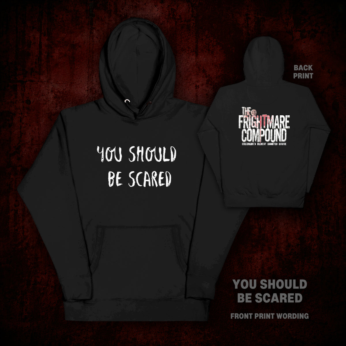 Black pullover hoodie shown from the front and back on a dark red textured background. The front reads 'YOU SHOULD BE SCARED' in white stylized text, and the back reads 'THE FREEMATHERS COMPOUND' with smaller white text.